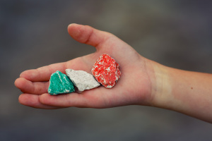 Child hand holding colored stones